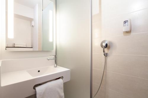 贡比涅B&B HOTEL Compiègne的白色的浴室设有水槽和淋浴。