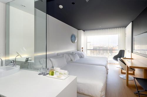 巴塞罗那桑特斯巴塞罗酒店的酒店客房配有床、书桌和水槽