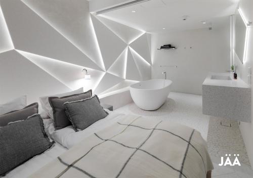 罗瓦涅米吉舍精品公寓式酒店的一间卧室配有一张床、一个浴缸和一个水槽