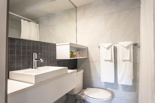 拉图克Hôtel Marineau La Tuque的白色的浴室设有水槽和卫生间。