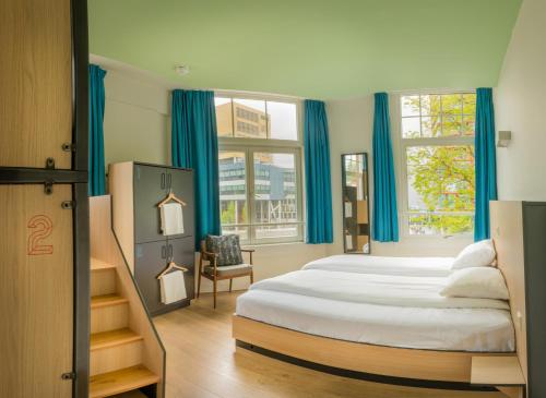 鹿特丹斯帕克斯旅舍的一间卧室配有一张带蓝色窗帘的大床