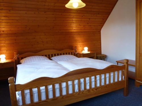 耶弗尔Hotel-Pension Stöber的一间卧室配有一张带两盏灯的大木床。