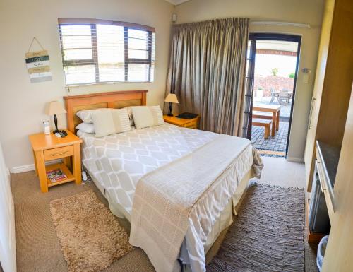 科尔切斯特River Rooms - Chilled and Relaxed - Colchester - 5km from Elephant Park的一间卧室设有一张床,并有通往阳台的门