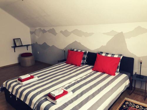 UdbinaArtisan House Meraki的一间卧室配有一张带红色枕头的大床