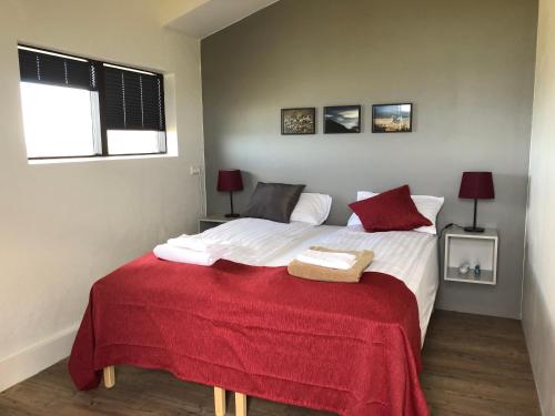 Reykjarholl吉姆波宾馆的一间卧室配有一张带红色毯子的大床
