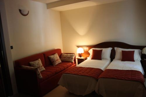 切萨纳·都灵尼斯奥林匹克山旅馆的酒店客房,配有床和沙发