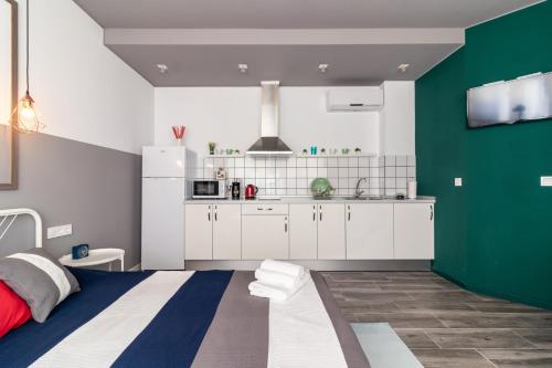 瓦伦西亚Apartamentos Navío的厨房配有白色橱柜和绿色墙壁