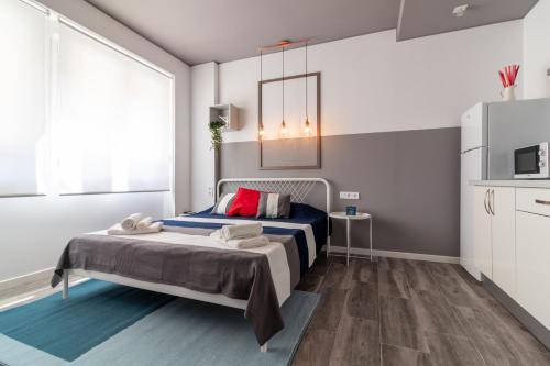 瓦伦西亚Apartamentos Navío的一间卧室设有一张床和一个大窗户