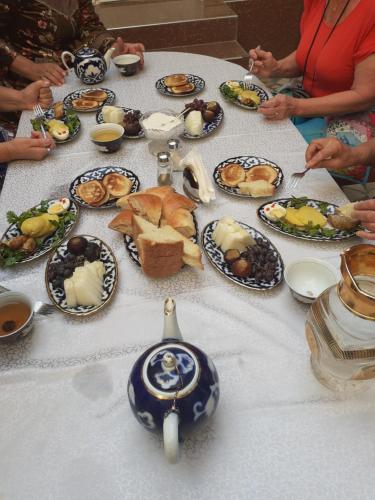 布哈拉Madina-Mehribon Welcome to Bukhara的餐桌上满盘食物的桌子