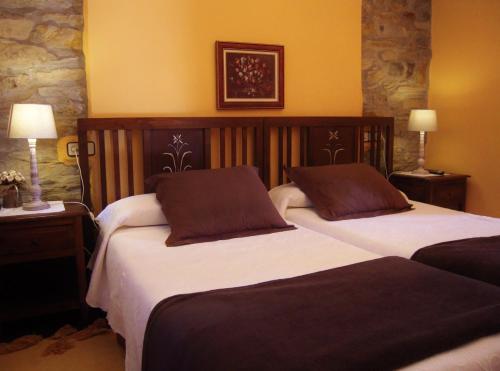 库迪列罗Hotel Rural Aguilar Cudillero的配有2盏灯的酒店客房的2张床