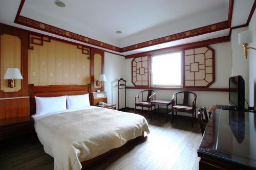 基隆华都饭店 的卧室配有一张床和一张桌子及椅子