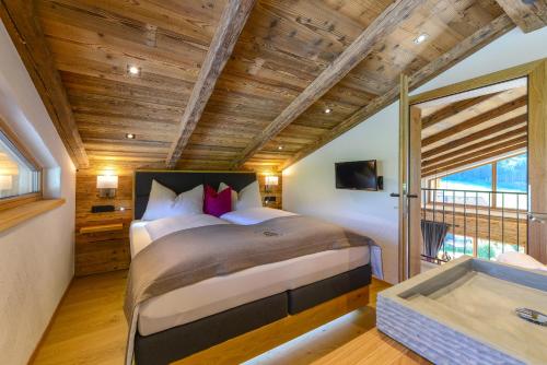 戈尔德格Gams Lodge的一间卧室设有一张大床和一个浴缸