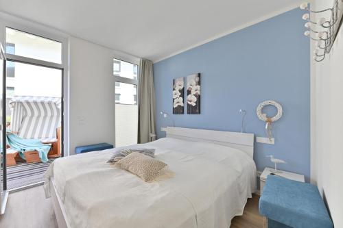 格洛韦Ferienwohnung Trauminsel的卧室配有白色的床和蓝色的墙壁