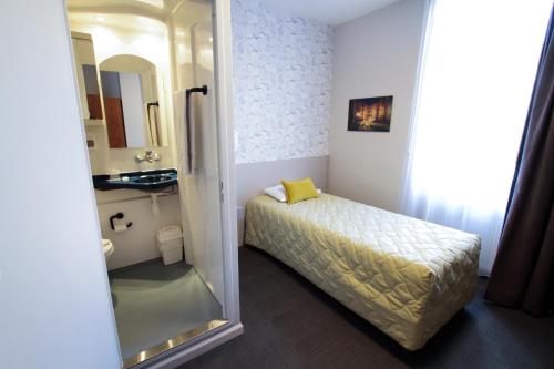 里昂让博斯科中心酒店的一间小卧室,配有一张床和镜子