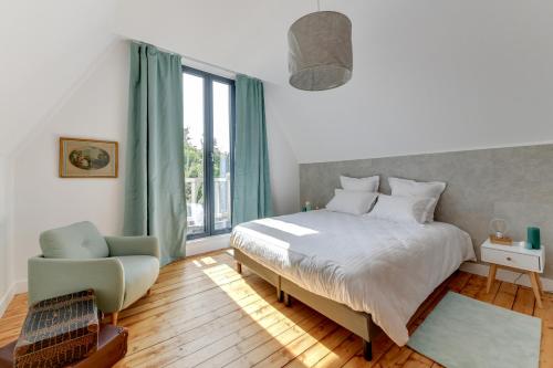 尚蒂伊Cottage de la Forêt的卧室配有床、椅子和窗户。