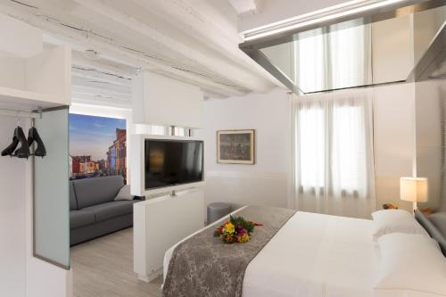 威尼斯UNAHOTELS Ala Venezia-Adults 16的白色卧室设有一张大床和一张沙发
