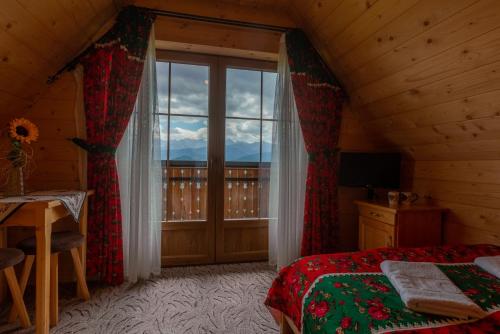 扎科帕内Domki na Gubałówce的一间卧室设有一张床和一个大窗户
