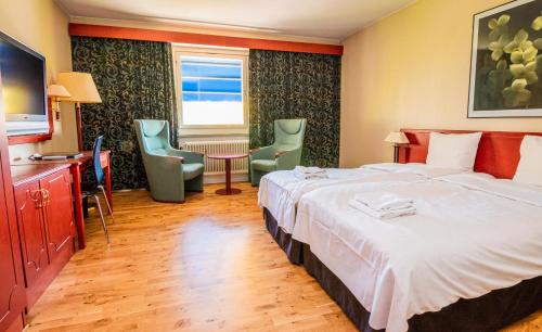 皮特奥Skoogs City BnB的酒店客房带一张床、一张桌子和椅子