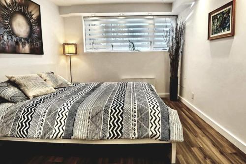 蒙特利尔Cosy apartment at Bossuet road的一间卧室设有一张大床、窗户和窗户