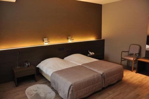奥德纳尔德德萨尔蒙酒店的一间卧室设有一张大床和黑色墙壁