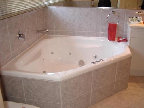 Gipsy Point吉普赛角湖畔酒店的带浴缸的浴室和瓷砖墙