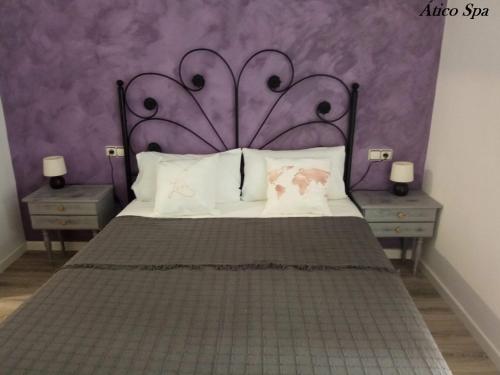 UcedaCasas Toya Jacuzzi的一间卧室配有一张大床和紫色墙壁