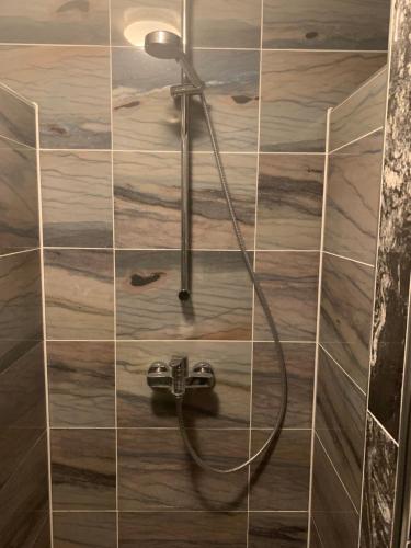 纽伦堡里诺膳食公寓酒店的瓷砖墙上带水管的淋浴