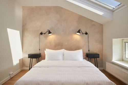 维也纳Hotel Babula am Augarten的一间卧室配有一张带两盏灯的大型白色床。
