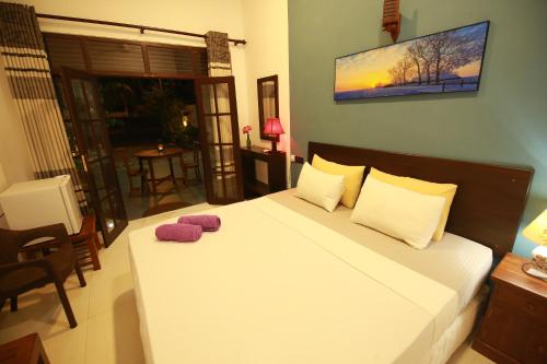 韦利格默Surf Lavender的一间卧室配有一张带两个紫色枕头的床