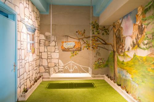 图尔古特雷斯Kortan Hotel的墙上挂有绘画,铺着绿色地毯的房间