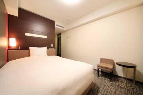 仙台里士满酒店普利米尔仙台站前的配有一张床和一把椅子的酒店客房