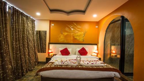 索拉哈皇家野生动物园酒店的一间卧室配有一张带红色枕头的大床