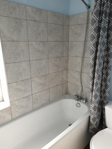 雷丁Tower House Hotel的浴室配有白色的浴缸和淋浴帘