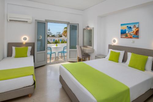 卡马利马卡里奥斯酒店的一间带两张床的卧室和一个带桌子的阳台