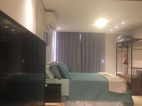 巴西利亚Charmoso e Confortável的一间卧室设有一张绿色的床和一个窗户。