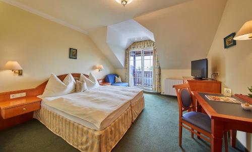 萨尔茨堡Hotel Die Pflegerbrücke的酒店客房配有一张床、一张书桌和一台电视。