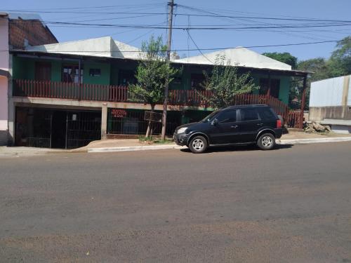 伊瓜苏港Hostel el Amanecer的停在大楼前的一辆黑色汽车