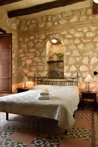 奥苏纳Casas Rurales Las Viñas的卧室配有一张石墙床