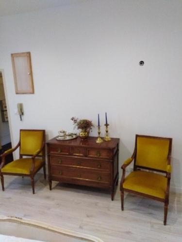 第戎Maponi的客房内的2把椅子和1个木制梳妆台