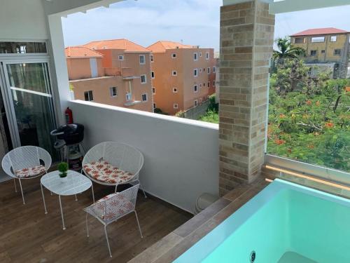 博卡奇卡KSL Residence的阳台设有游泳池和桌椅。