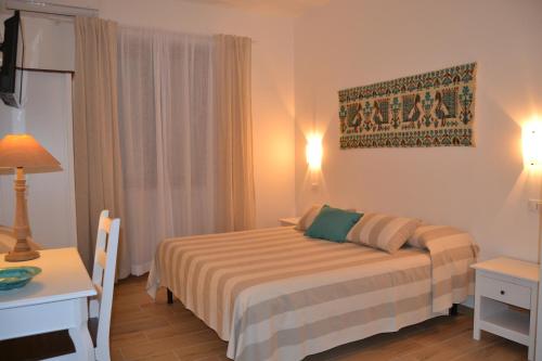 努奥罗Nuscos Bed and Breakfast的酒店客房配有一张床铺、一张桌子和一张书桌。
