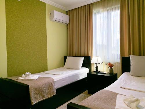 库塔伊西Garden Hotel的酒店客房设有两张床和窗户。