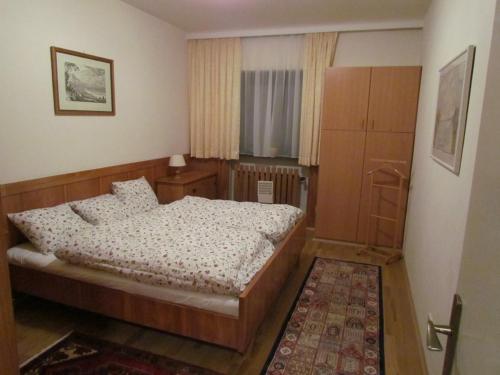 蒂罗尔-泽费尔德Apartment Sophia的一间卧室配有一张床,一扇门通往一个房间