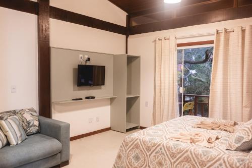 阿布拉奥Flat Bouganville的一间卧室配有一张床、一台电视和一张沙发