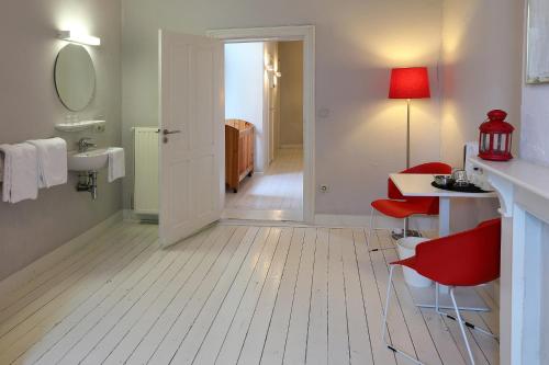 弗尔内德阁楼酒店的浴室配有水槽、桌子和红色椅子