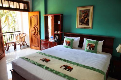 康提Serenity Hill Oasis的一间卧室设有一张带绿色墙壁的大床