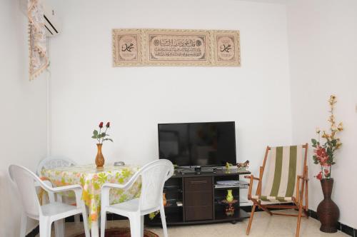RadèsCity Apartment Rades Tunis free Wifi的一间带桌椅和电视的用餐室
