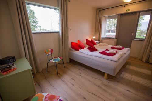 瓦玛里德Hestasport Apartment的一间卧室配有一张带红色枕头的大床