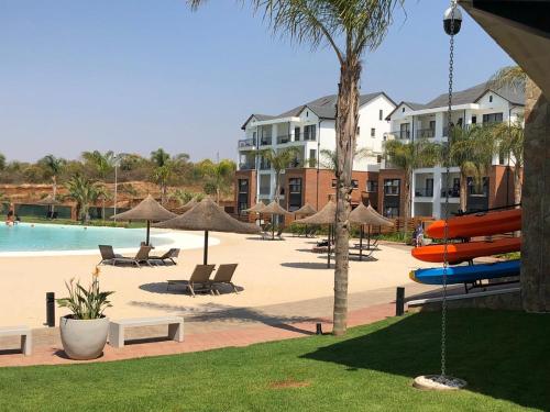 比勒陀利亚The Blyde Riverwalk Estate的一个带椅子和遮阳伞的游泳池的度假酒店