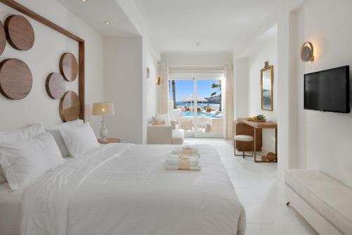 普拉迪斯亚罗斯尼萨基精品酒店的白色的卧室配有一张白色的大床和电视。